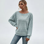 Woman wearing mint green textured knit sweater with batwing sleeves, studio photo