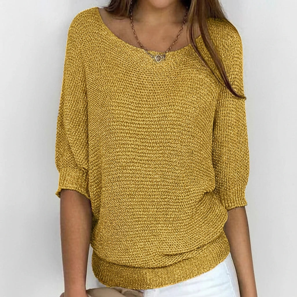 Woman wearing a mustard yellow relaxed knit sweater with wide neckline, alternate studio angle