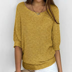 Woman wearing a mustard yellow relaxed knit sweater with wide neckline, alternate studio angle
