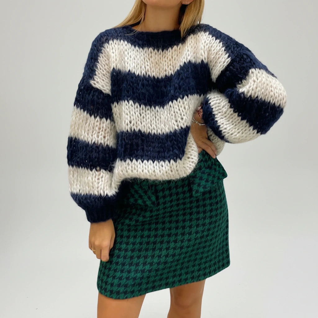 Woman wearing a navy blue striped chunky knit sweater, alternate studio angle