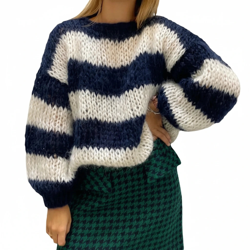 Woman wearing a navy blue striped chunky knit sweater, front view
