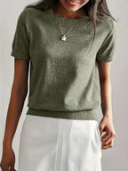 Woman wearing an olive green fine knit sweater with short sleeves, side view