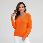 Woman wearing orange ribbed V-neck sweater, studio photo