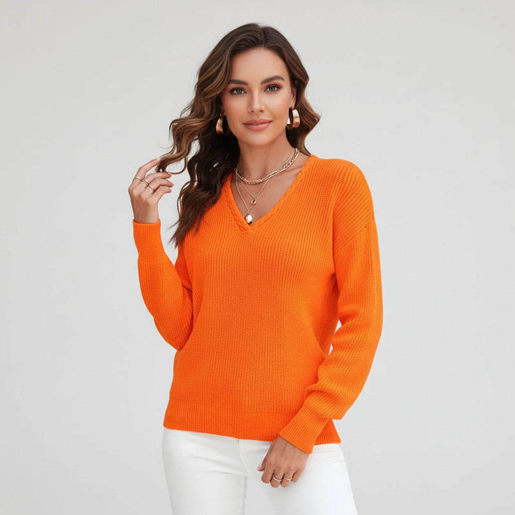 Woman wearing orange ribbed V-neck sweater, studio photo