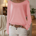 Woman wearing a pink lightweight boat neck sweater indoors, lifestyle shot