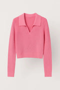 Woman wearing pink ribbed cropped V-neck sweater with collar