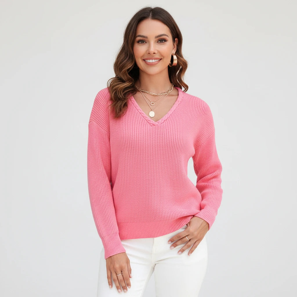 Woman wearing pink ribbed V-neck sweater, studio photo