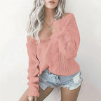 Woman wearing pink oversized openwork sweater with cable texture, studio photo
