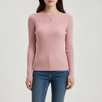 Woman wearing pink ribbed boat neck sweater, studio photo
