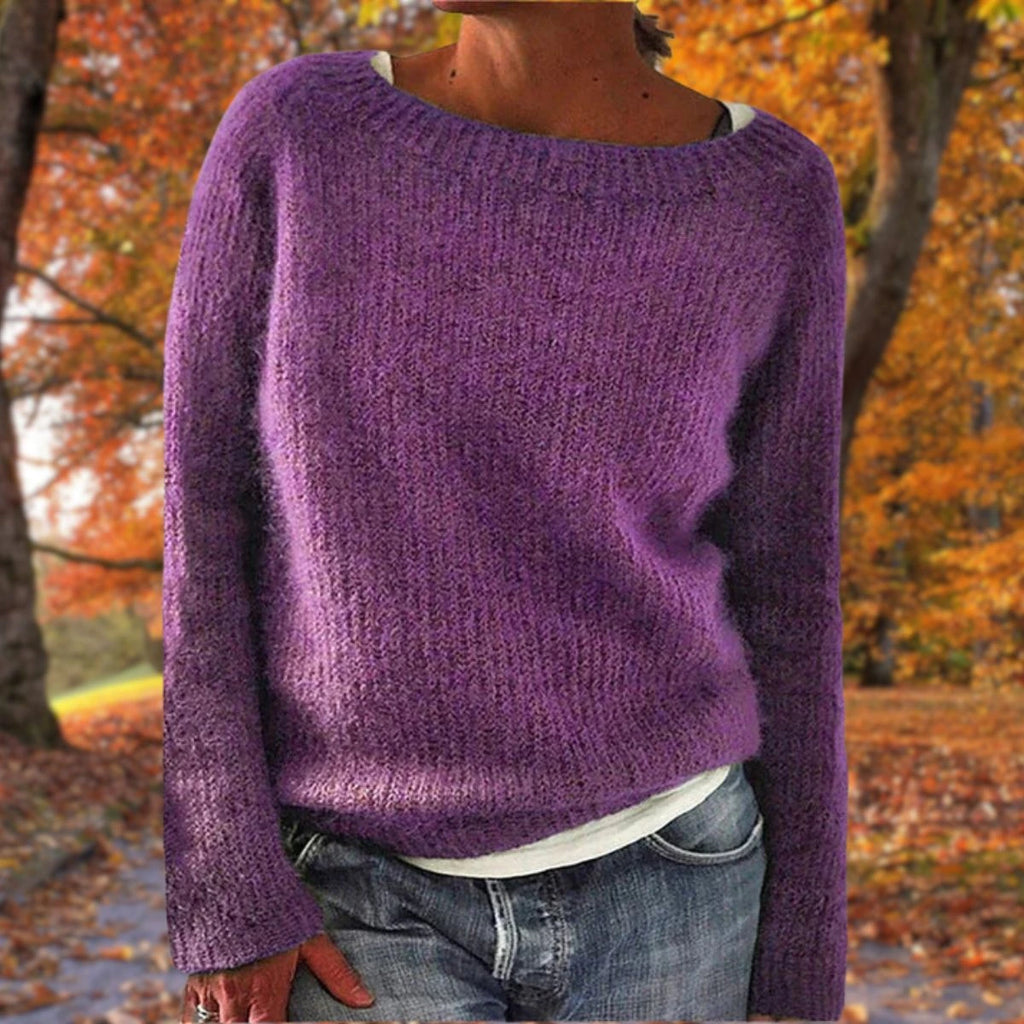 Woman wearing a purple merino wool sweater with an autumn background