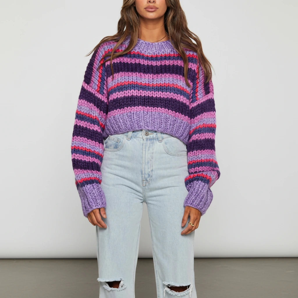Woman wearing a purple striped chunky knit sweater with balloon sleeves, studio shot