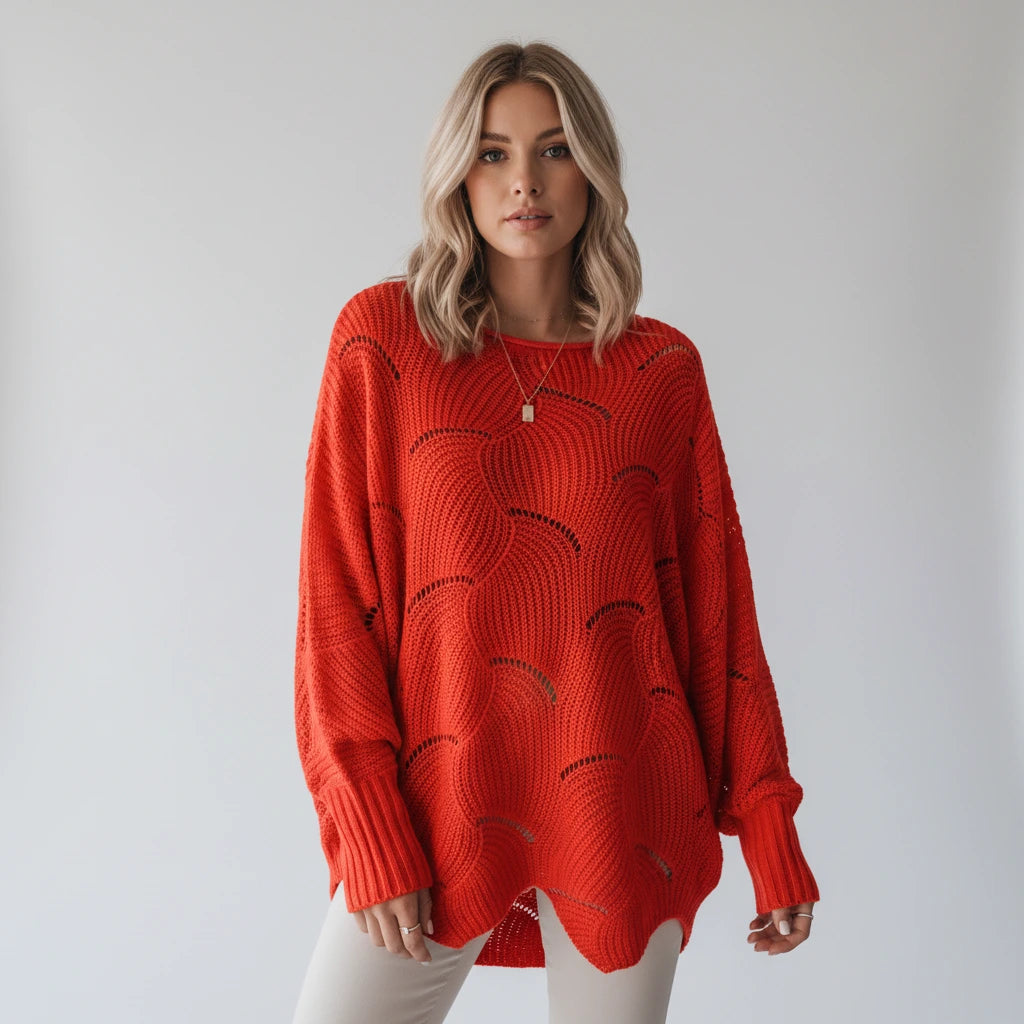 Woman wearing a red oversized open knit sweater with draped asymmetric hem, studio shot