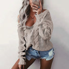 Woman wearing taupe oversized openwork sweater with cable texture, studio photo