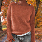Woman wearing a terracotta merino wool sweater with an autumn background