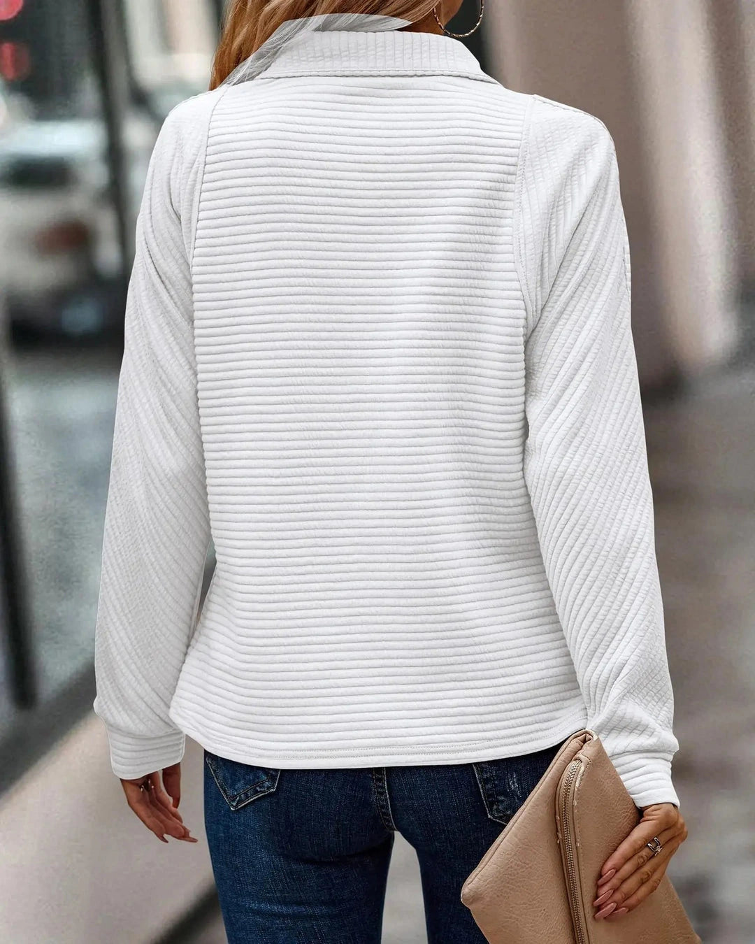 White ribbed quarter-zip sweater with raised collar, flat lay
