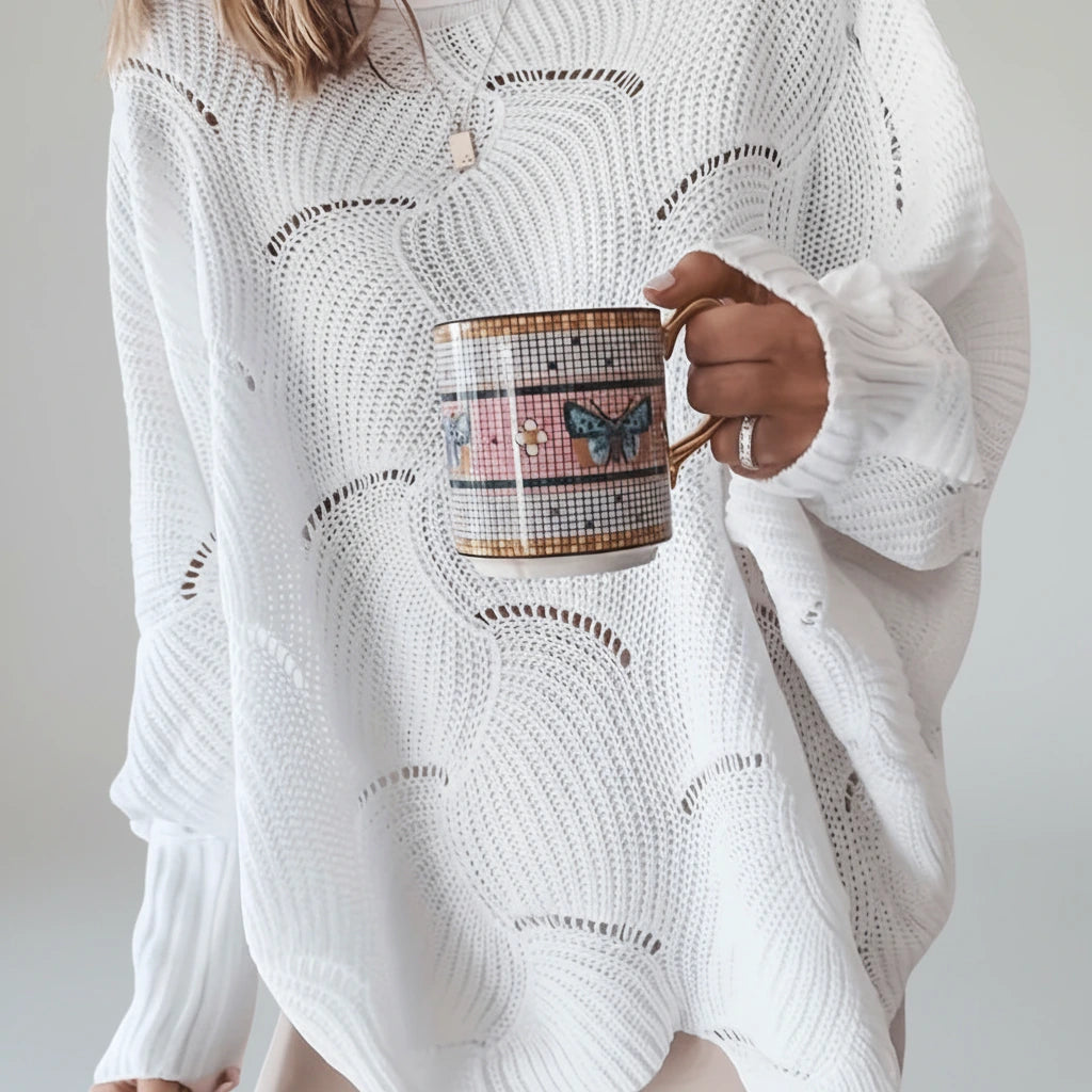 Close-up of white oversized open knit sweater texture and sleeve