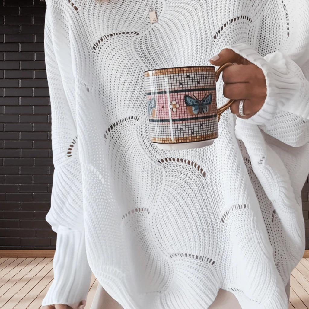 Close-up of white oversized open knit sweater fabric and hem detail
