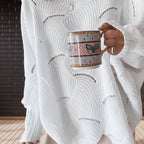 Close-up of white oversized open knit sweater fabric and hem detail