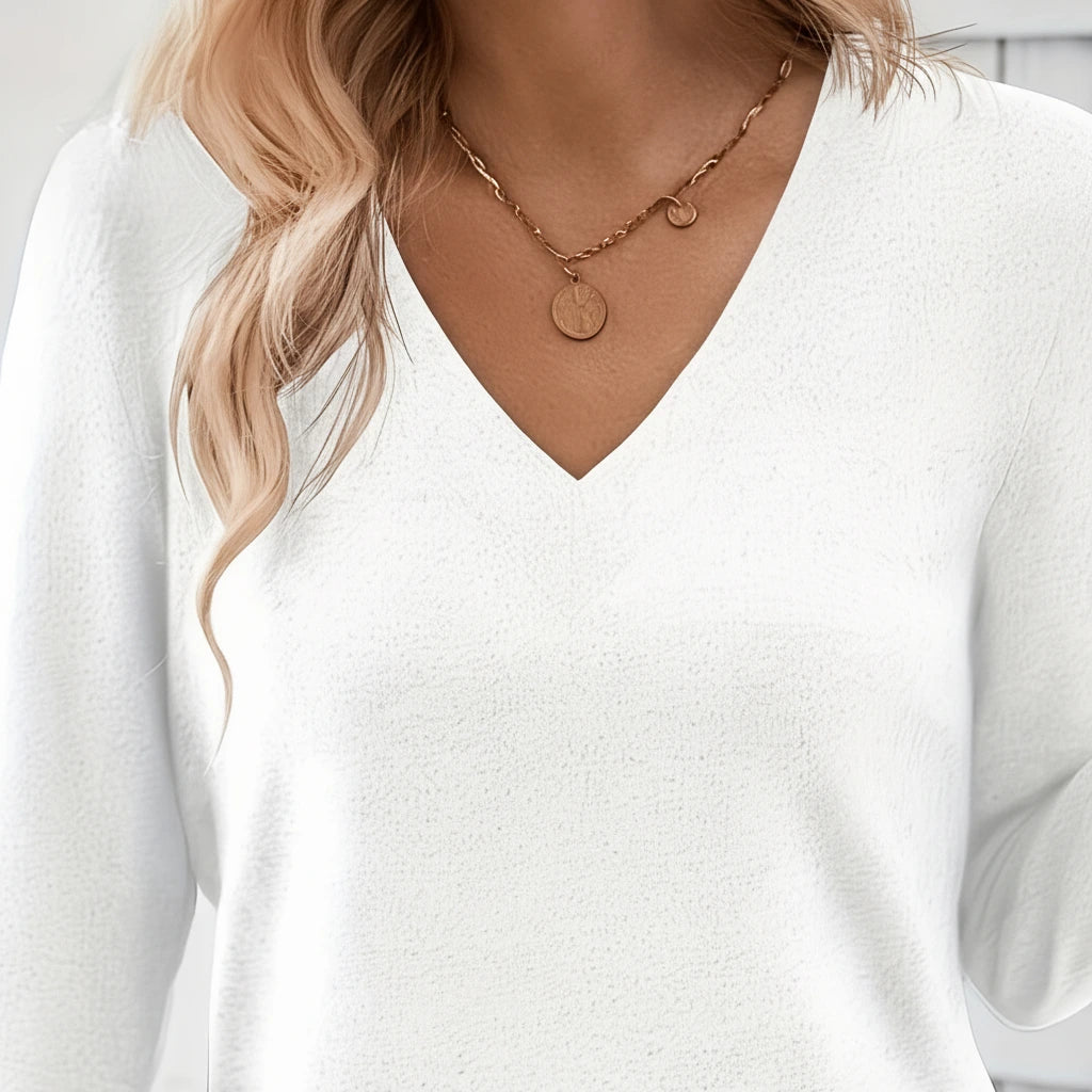 Close-up of white V-neck sweater neckline detail