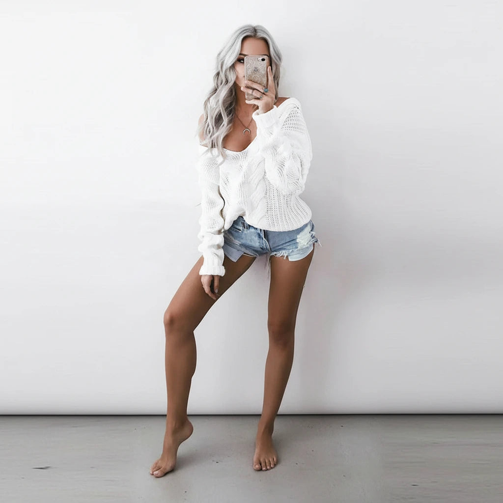 Woman wearing white oversized openwork sweater with cable texture, full body view