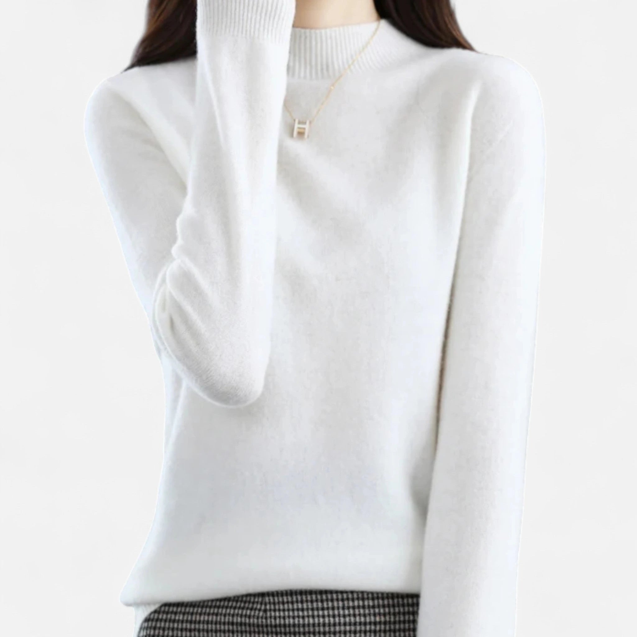 Woman wearing a white wool half-neck sweater in a studio setting