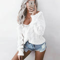 Woman wearing white oversized openwork sweater with cable texture, studio photo
