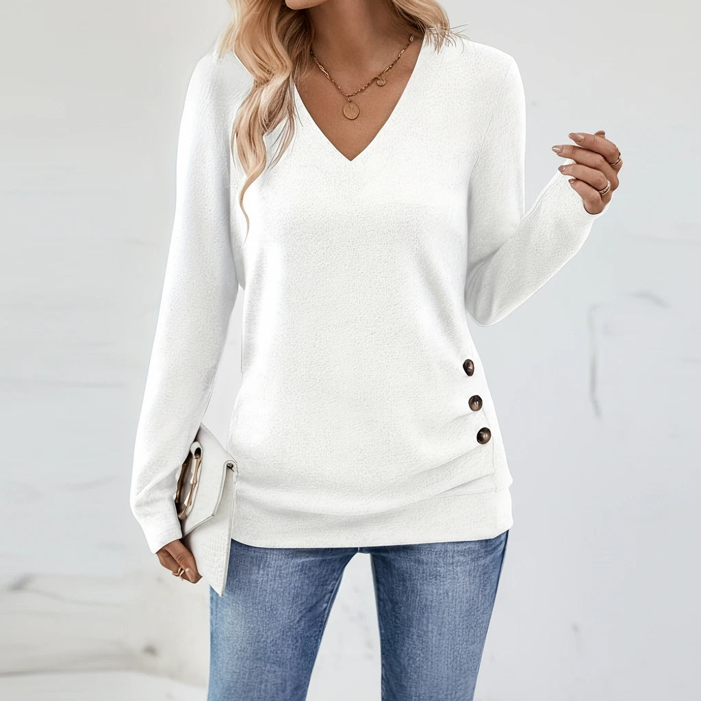 Woman wearing white V-neck sweater with side button detail, studio photo