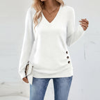 Woman wearing white V-neck sweater with side button detail, studio photo