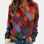 Woman wearing a wine red colorblock diamond knit sweater with long sleeves