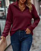 Woman wearing wine red ribbed quarter-zip sweater with raised collar
