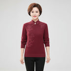 Woman wearing wine red high-collar sweater with printed button detail, studio photo