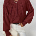 Woman wearing a wine red voluminous sleeve sweater with cable knit texture