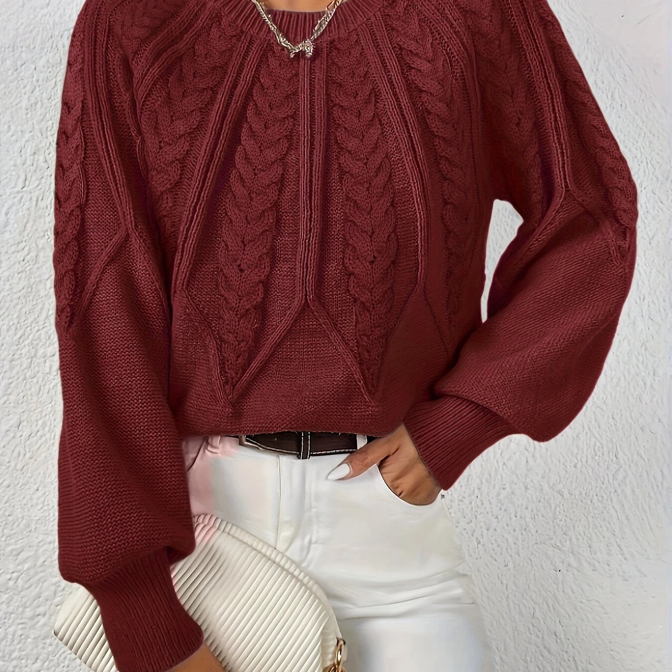 Woman wearing a wine red voluminous sleeve sweater with cable knit texture