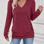 Woman wearing wine red V-neck sweater with side button detail, studio photo