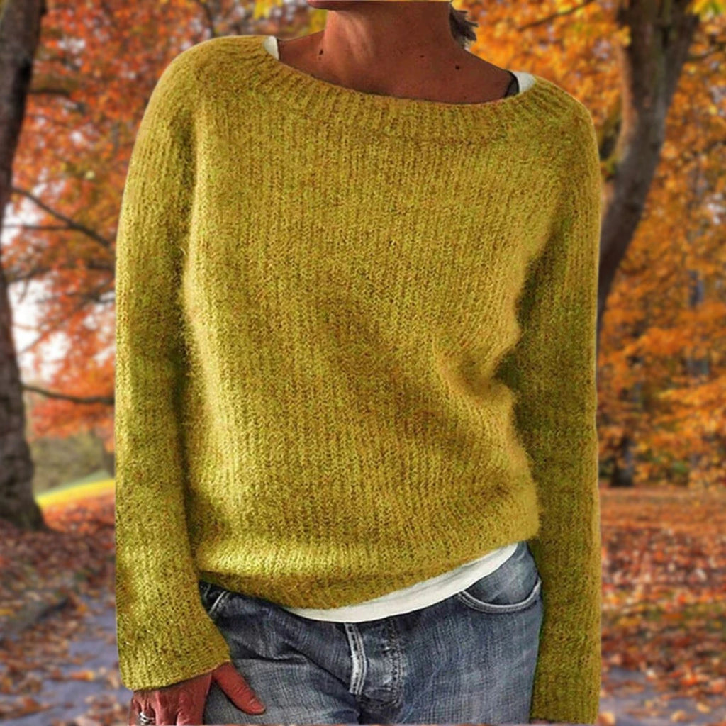 Woman wearing a yellow merino wool sweater with an autumn background