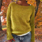 Woman wearing a yellow merino wool sweater with an autumn background