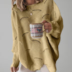 Woman wearing a yellow oversized open knit sweater with draped asymmetric hem, studio shot