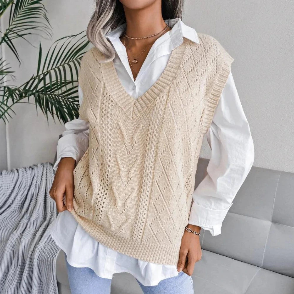 Woman wearing a beige openwork sweater vest with ribbed V neck over a white shirt