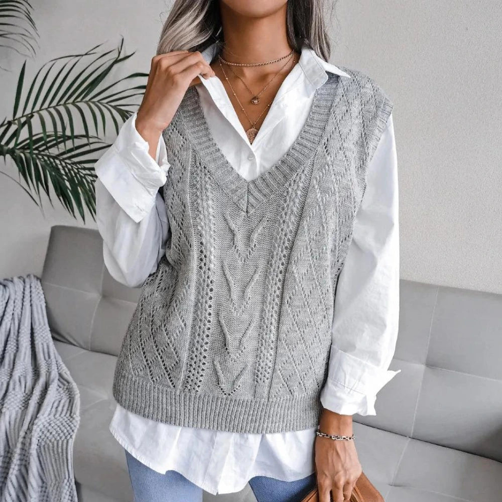 Woman wearing a grey openwork sweater vest with ribbed V neck over a white shirt