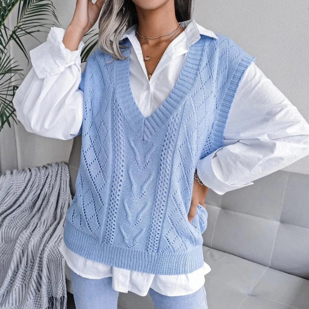 Woman wearing a light blue openwork sweater vest with ribbed V neck over a white shirt