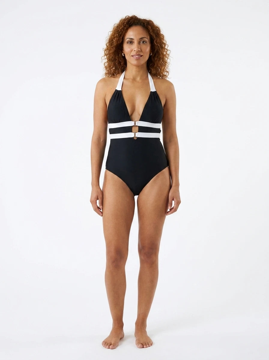 Woman wearing a black and white striped plunge one-piece swimsuit, studio photography, front view