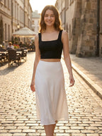 Driftly women's black polyester cropped tank top with a slash neckline, styled with a white midi skirt on a European street at golden hour.