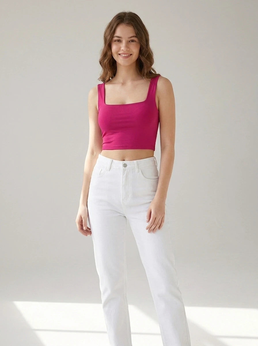 Driftly women's fuchsia polyester cropped tank top with a slash neckline, styled with white jeans in a minimalist studio setting.