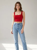 Driftly women's red polyester cropped tank top with a slash neckline, styled with blue jeans in a minimalist studio setting.