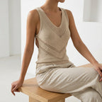 Driftly women's khaki sleeveless V-neck tank top, styled with beige linen trousers, seated in a bright interior.