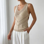Driftly women's khaki sleeveless V-neck tank top, styled with white wide-leg trousers in a minimalist studio setting.