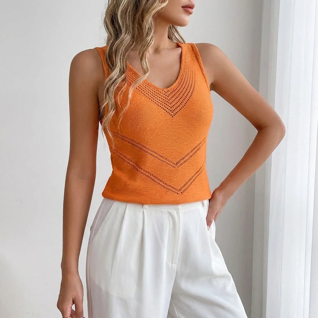 Driftly women's orange sleeveless V-neck tank top, styled with white wide-leg trousers in a minimalist studio setting.