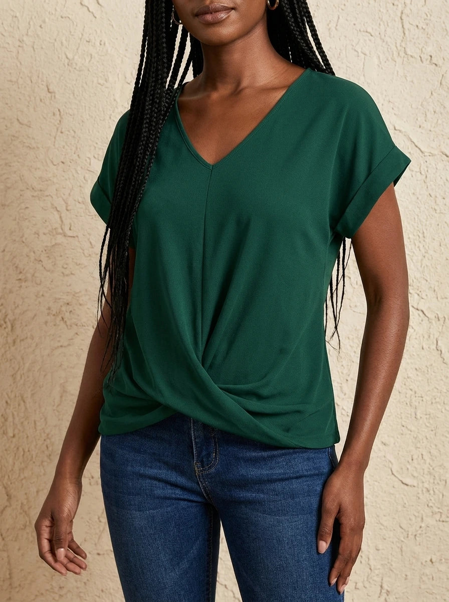Woman wearing a green v-neck twist front short sleeve top with jeans