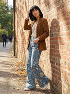 Woman wearing blue bohemian print wide-leg trousers, different pose against a brick wall