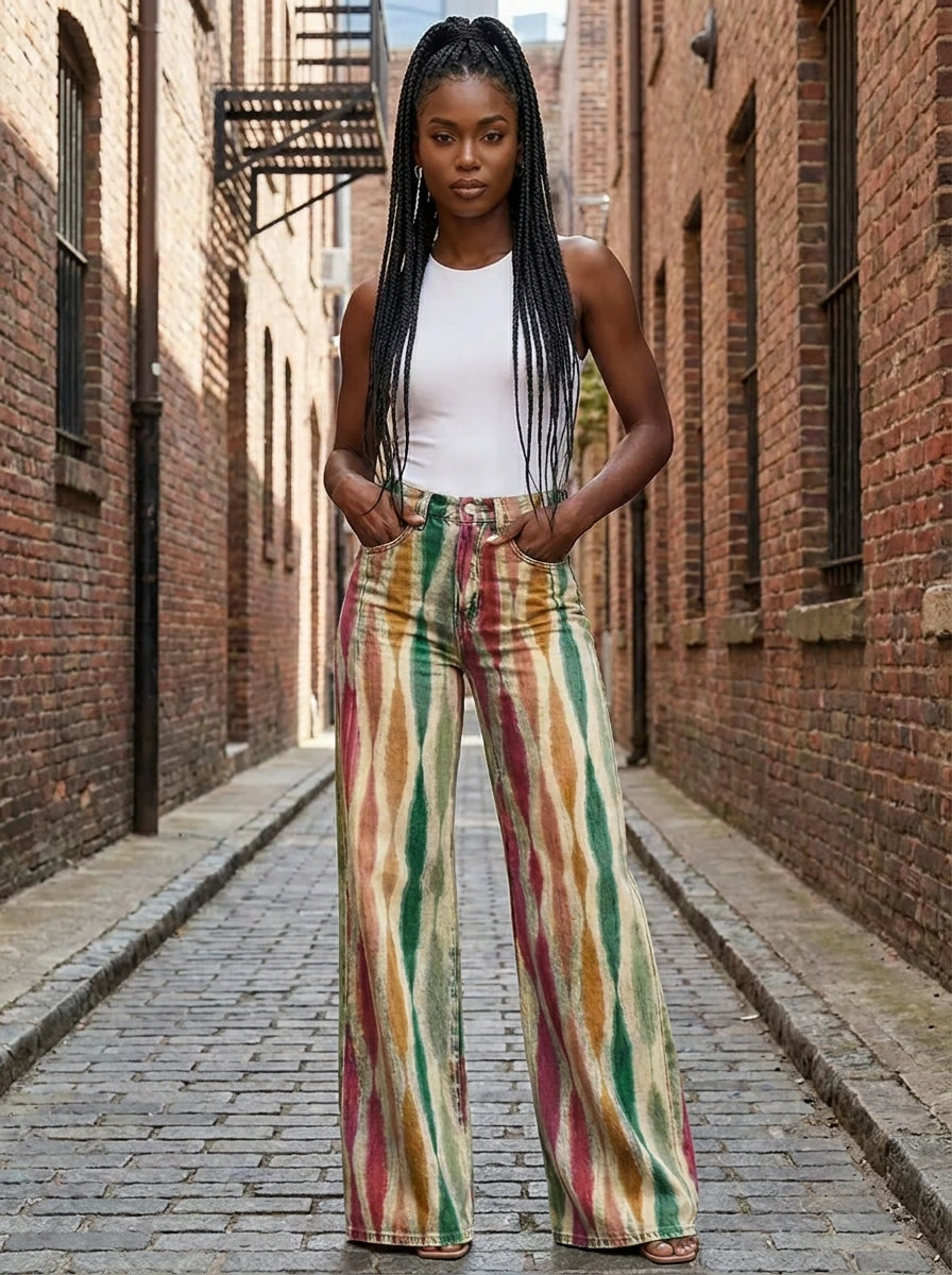 Woman in multicolor striped bohemian wide-leg trousers standing in a brick alley